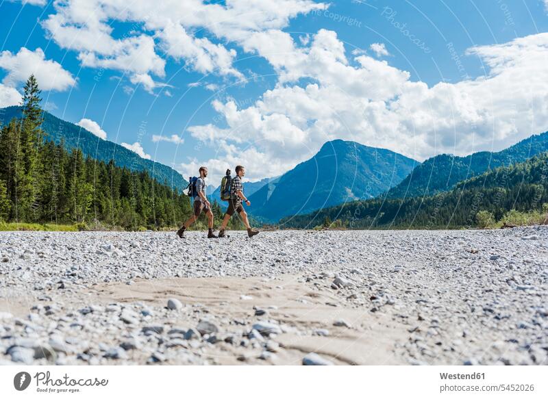 Germany, Bavaria, two hikers walking in dry creek bed friends wanderers friendship hiking river bed riverbed hiking vacation hiking holidays hiking tour