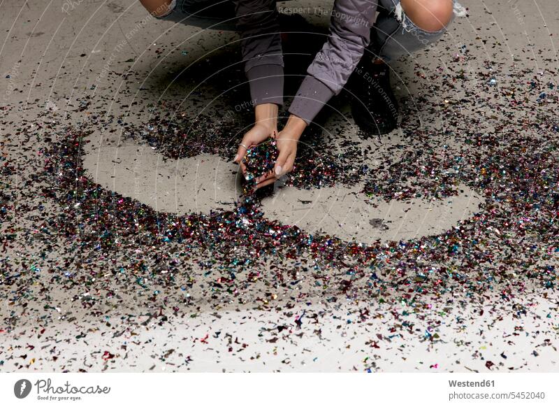 Woman's hands collecting confetti from the floor human hand human hands Floor Floors woman females women people persons human being humans human beings floors