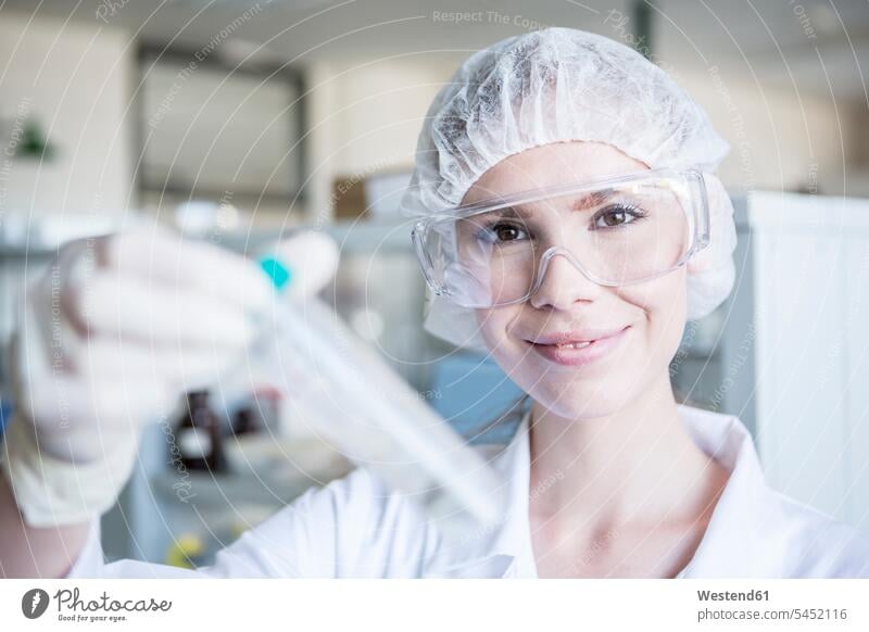 Portrait of smiling scientist in lab holding test tube science sciences scientific working At Work smile laboratory woman females women portrait portraits