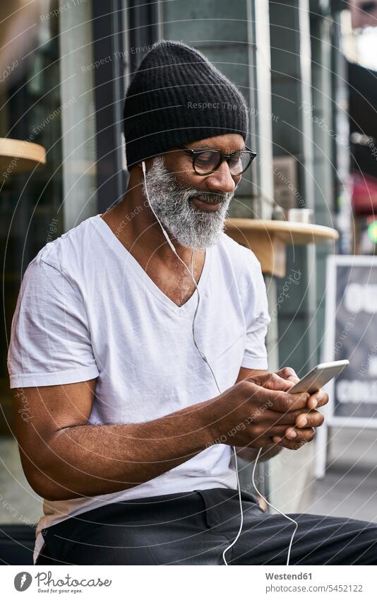 Mature man using smartphone in coffee shop Businessman Business man Businessmen Business men text messaging SMS Text Message reading on the move on the way
