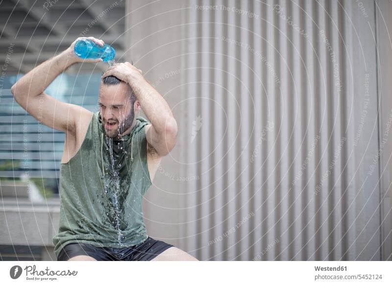 Athlete taking a break pouring water over his head Water man men males exercising exercise training practising Drink beverages Drinks Beverage food and drink