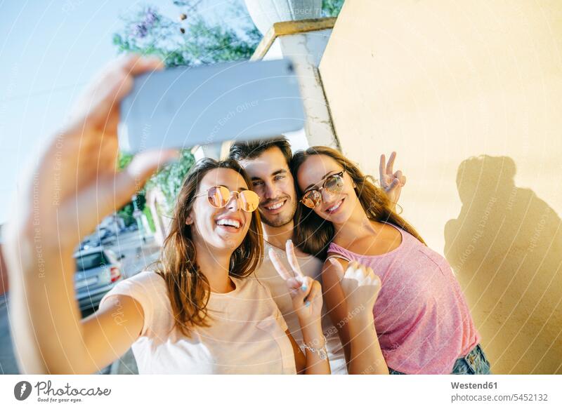 Friends taking a selfie with smartphone on the street mobile phone mobiles mobile phones Cellphone cell phone cell phones friends Selfie Selfies Fun having fun