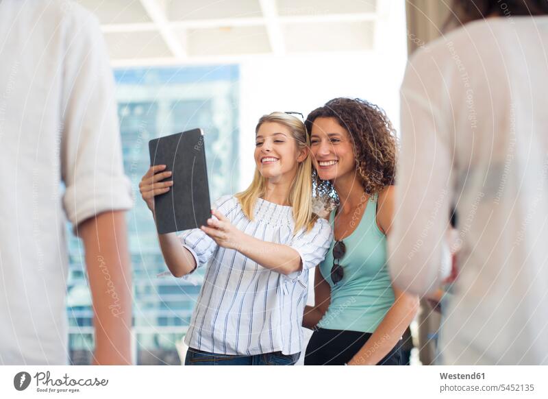 Two happy women taking a selfie with tablet on urban square female friends colleagues digitizer Tablet Computer Tablet PC Tablet Computers iPad Digital Tablet