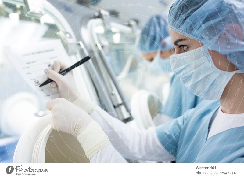 Scientist taking notes in laboratory making a note note taking scientist writing write science sciences scientific workplace work place place of work working