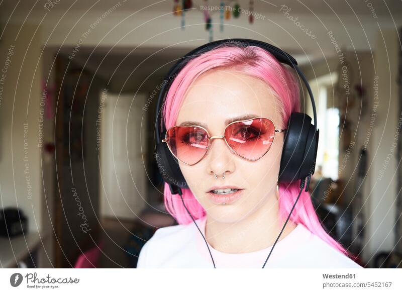 Portrait of young woman with pink hair and heart-shaped sunglasses listening to music specs Eye Glasses spectacles Eyeglasses females women portrait portraits