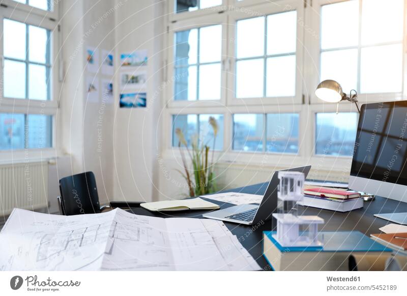 Desk with construction plan in a modern informal office laptop Laptop Computers laptops notebook empty emptiness offices office room office rooms computer