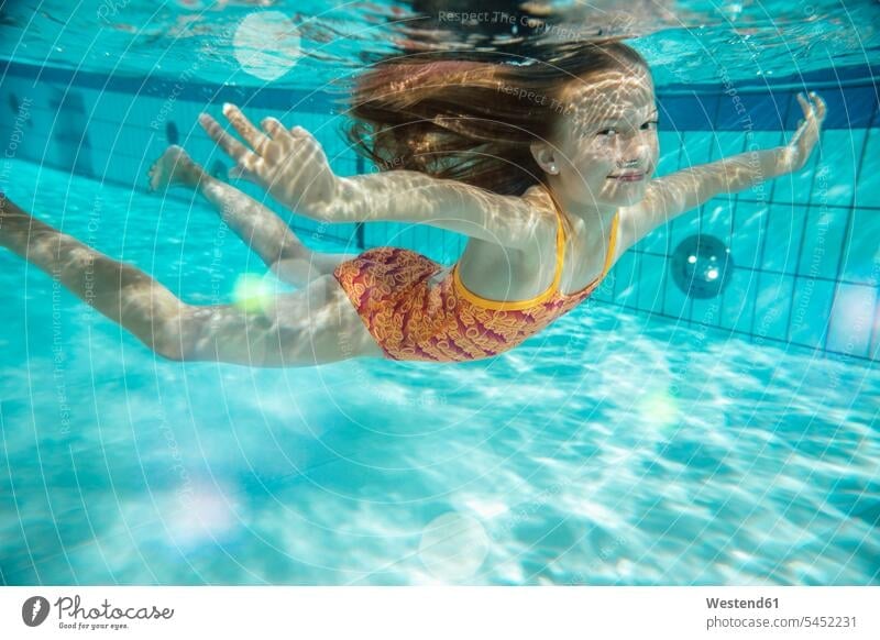 Portrait of smiling girl swimming under water in swimming pool smile portrait portraits underwater submerged Under Water underwater shot underwater shots