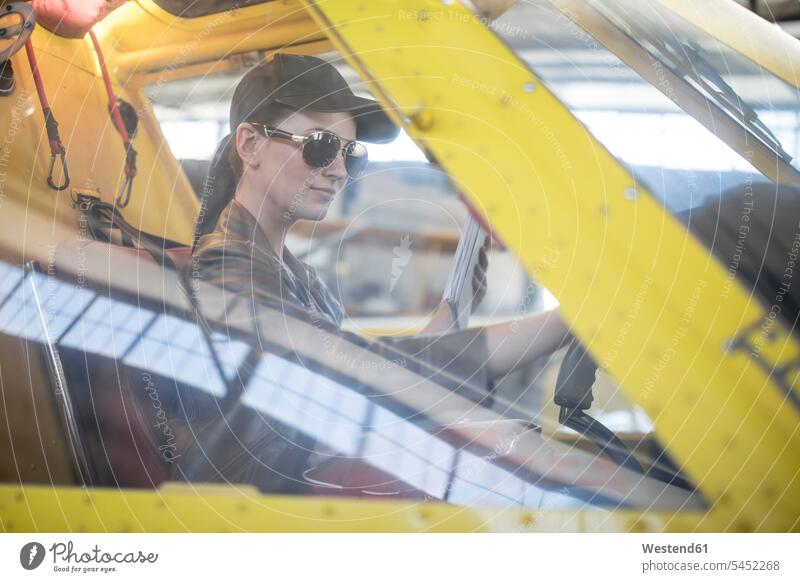Female pilot inspecting light aircraft cockpit sitting Seated checking Test testing Check female pilot female pilots airplane aeroplanes airplanes Air Vehicle