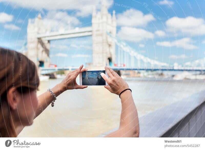UK, London, woman taking a picture of the Tower Bridge mobile phone mobiles mobile phones Cellphone cell phone cell phones females women photographing
