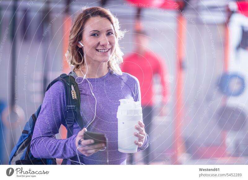 Portrait of smiling young woman in gym exercising exercise training practising smile females women gyms Health Club break Adults grown-ups grownups adult people