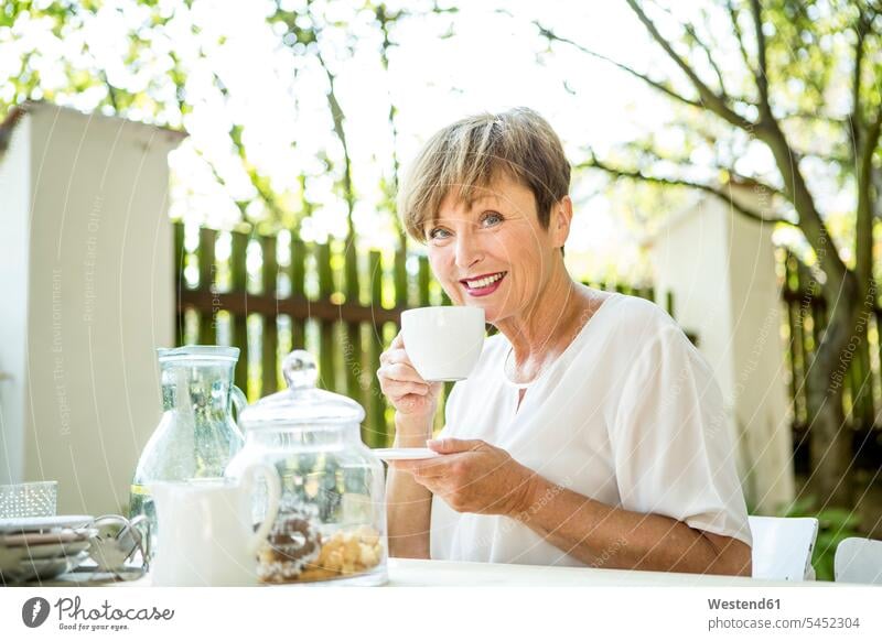 Portrait of smiling senior woman drinking cup of coffee outdoors senior women elder women elder woman old Coffee females smile senior adults Adults grown-ups