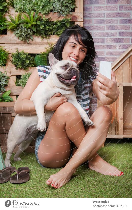 Woman and french bulldog taking a selfie on the terrace dogs Canine Selfie Selfies woman females women smiling smile mobile phone mobiles mobile phones