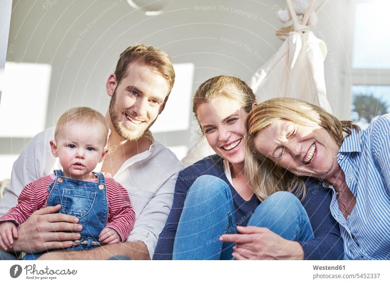 Portrait of happy familiy with baby girl at home laughing Laughter infants nurselings babies Fun having fun funny happiness family families positive Emotion