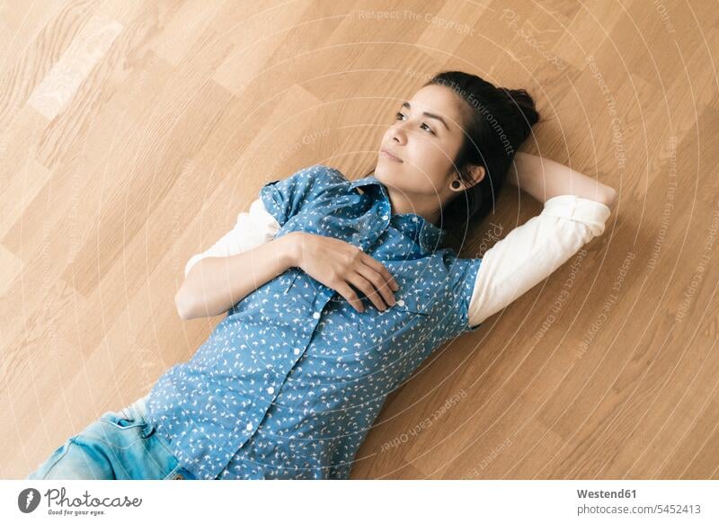 Woman lying on wooden floor laying down lie lying down wooden floors woman females women Adults grown-ups grownups adult people persons human being humans