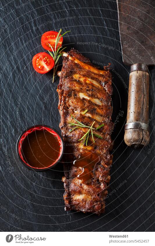 Marinated and grilled spare ribs with bowl of Barbecue sauce on slate overhead view from above top view Overhead Overhead Shot View From Above spring onion