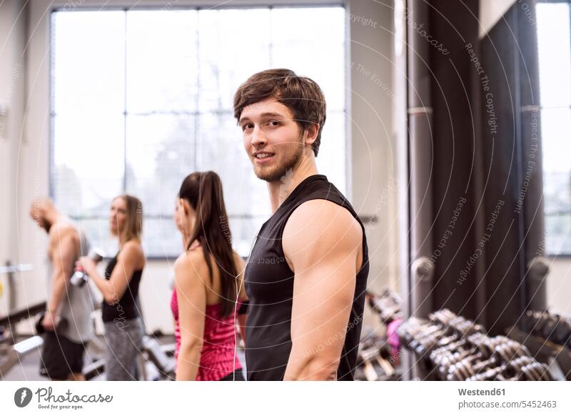 Young people exercising in gym young man young men exercise training practising young women young woman gyms Health Club fit males Adults grown-ups grownups