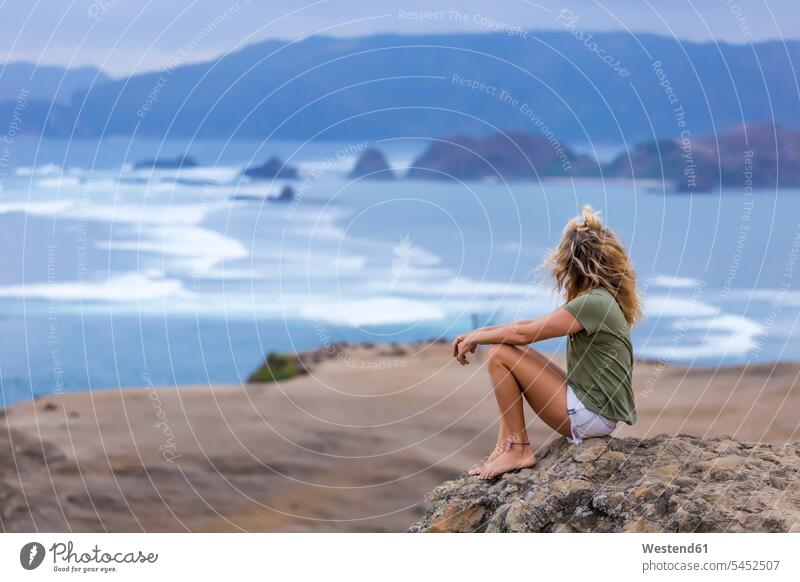 Indonesia, Lombok, woman sitting at the coast looking at view coastline shoreline View Vista Look-Out outlook females women Seated Adults grown-ups grownups