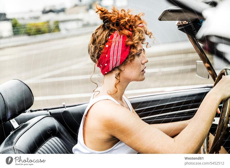 Redheaded woman in sports car driving drive females women automobile Auto cars motorcars Automobiles Adults grown-ups grownups adult people persons human being