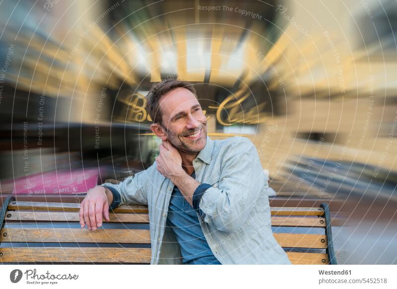 Portrait of smiling mature man sitting on wooden bench portrait portraits men males Adults grown-ups grownups adult people persons human being humans