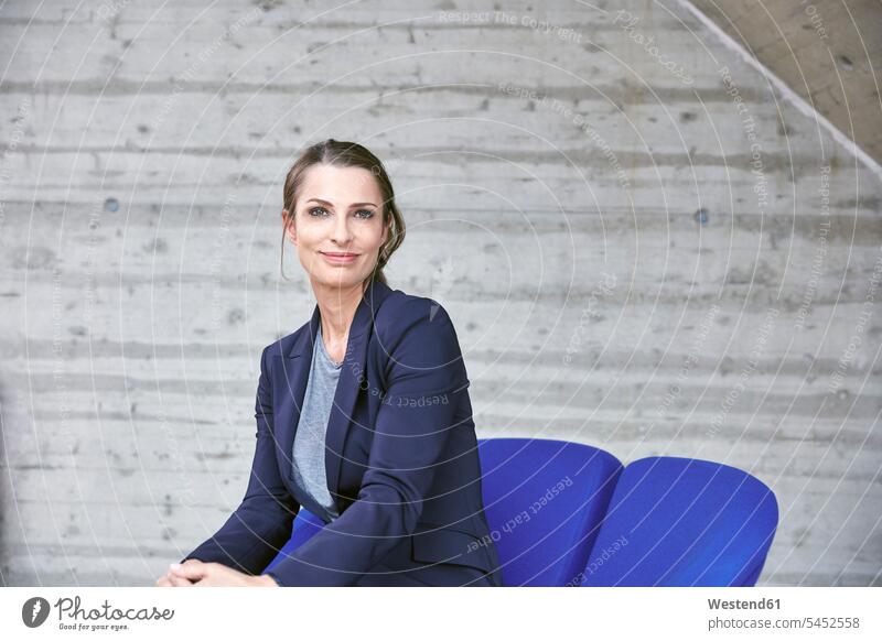Smiling businesswoman sitting on chair portrait portraits Seated businesswomen business woman business women smiling smile business people businesspeople