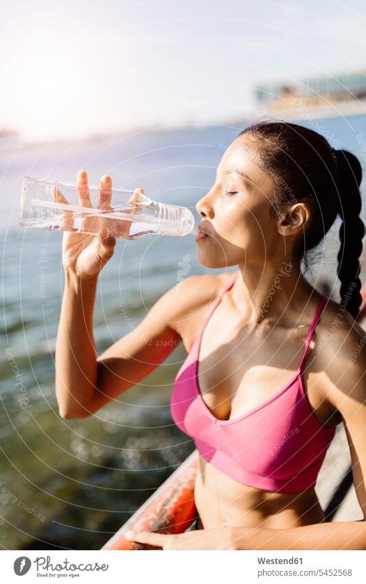 Active woman drinking water from drinking bottle Water training Sport Training Refreshment refreshing active females women Thirst thirsty Drink beverages Drinks