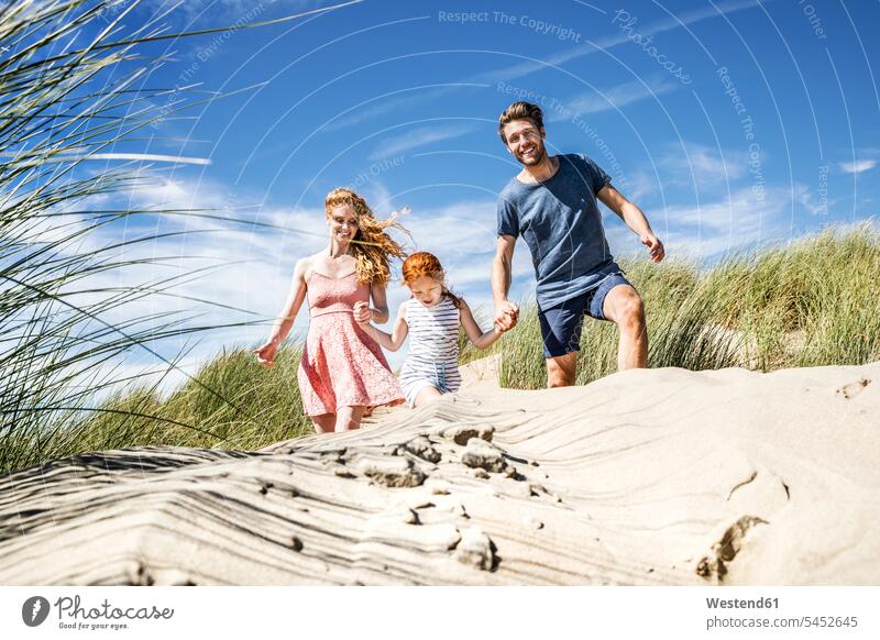 Netherlands, Zandvoort, happy family with daughter in beach dunes families beaches happiness sand dune sand dunes Fun having fun funny people persons