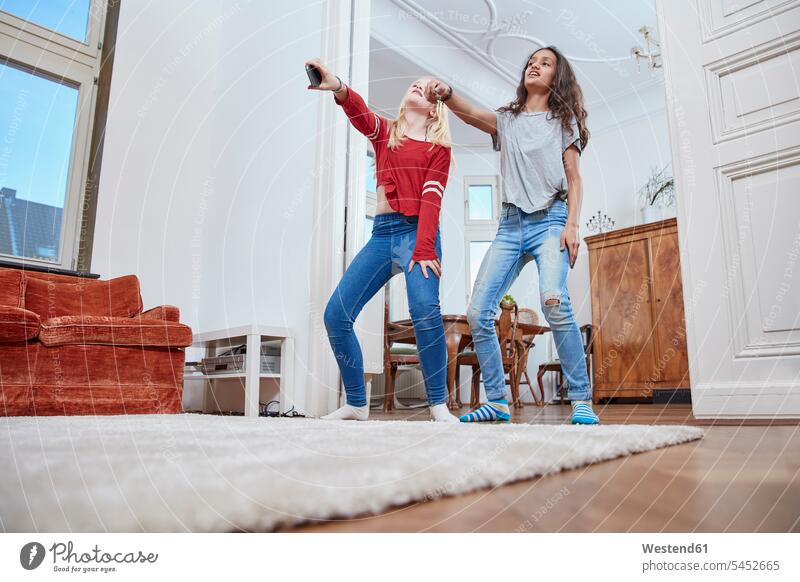 Two girls dancing at home dance female friends females mate friendship child children kid kids people persons human being humans human beings Hand Raised