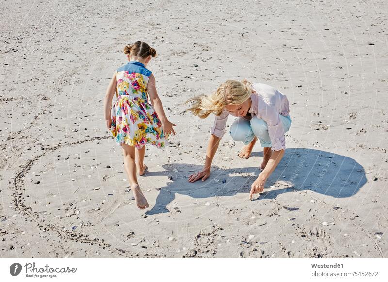 Mother and daughter drawing heart on the beach mother mommy mothers ma mummy mama daughters beaches happiness happy parents family families people persons