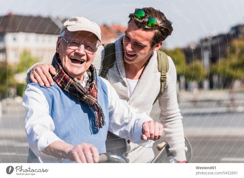 Happy senior man with adult grandson in the city on the move happiness happy laughing Laughter grandsons grandfather grandpas granddads grandfathers Fun