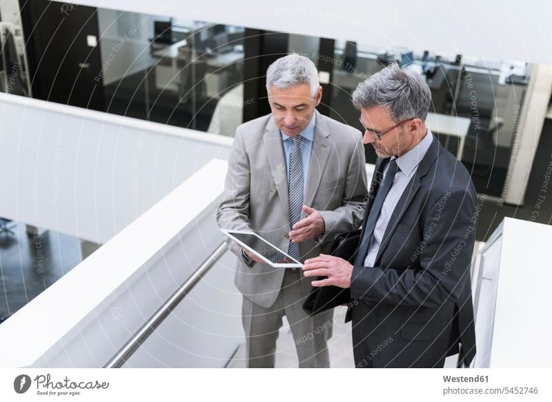 Two businessmen having an informal meeting, using digital tablet together digitizer Tablet Computer Tablet PC Tablet Computers iPad Digital Tablet