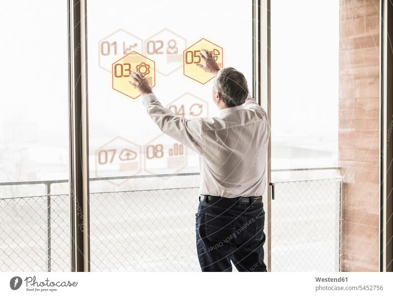 Businessman touching windowpane with data in office Business man Businessmen Business men business people businesspeople business world business life offices