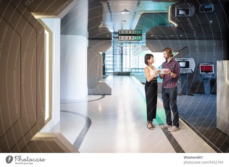 Business people discussing in an office corridor sharing share Office Offices Female Colleague discussion futuristic the future visionary hallway corridors