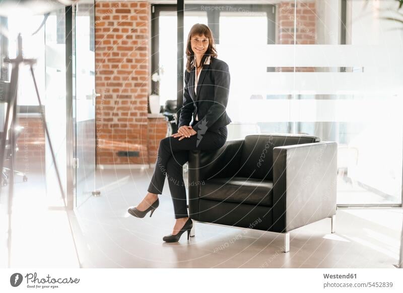 Successful businesswoman sitting on armchair expertise competence competent Office Offices happiness happy businesswomen business woman business women