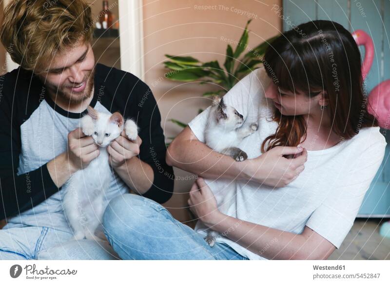 Young couple with kittens at home twosomes partnership couples cat cats people persons human being humans human beings pets animal creatures animals looking