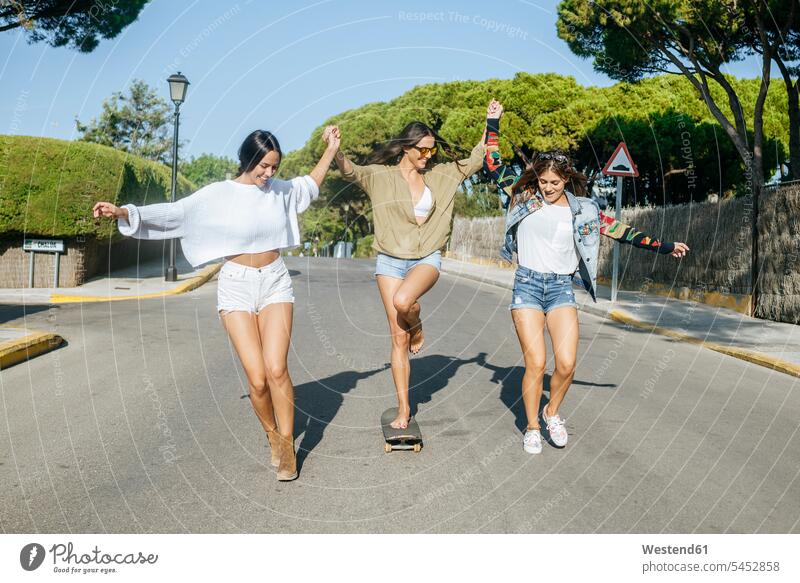Three friends having fun together female friends Fun funny mate friendship Hot Pants skateboard Skate Board skateboards exuberance hilarity Frolic exuberant
