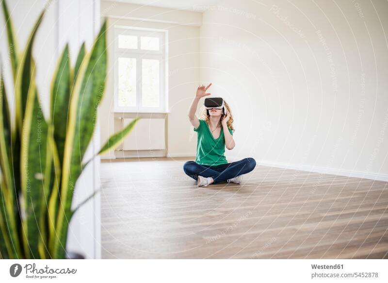 Woman in empty apartment wearing VR glasses flat flats apartments Virtual Reality Glasses Virtual-Reality Glasses virtual reality headset vr headset vr goggles