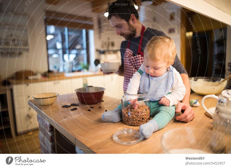 Father and baby boy in kitchen baking a cake Sprinkles father pa fathers daddy dads papa son sons manchild manchildren bake pies cakes parents family families