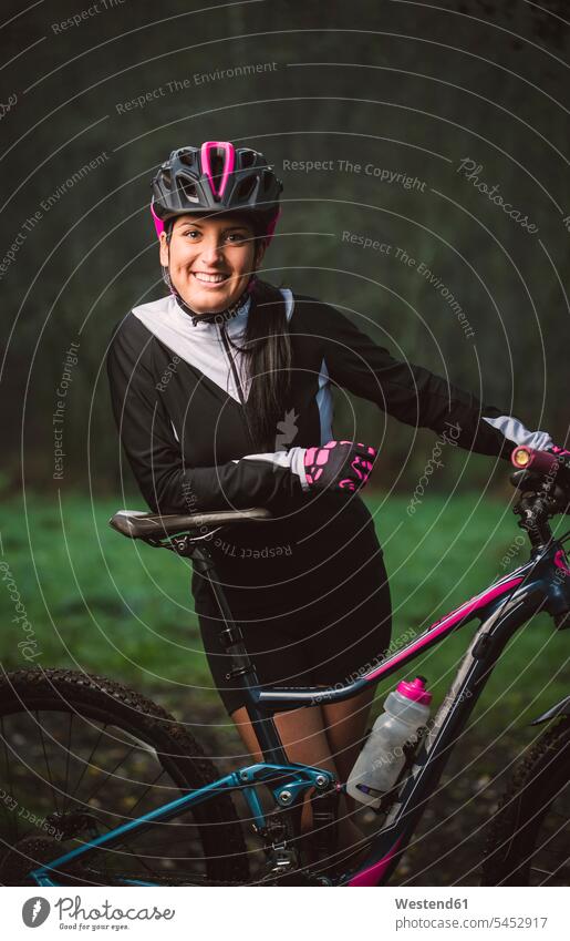 Portrait of smiling woman with mountain bike smile females women mountain biking MTB mountainbiking bicycle bikes bicycles Adults grown-ups grownups adult