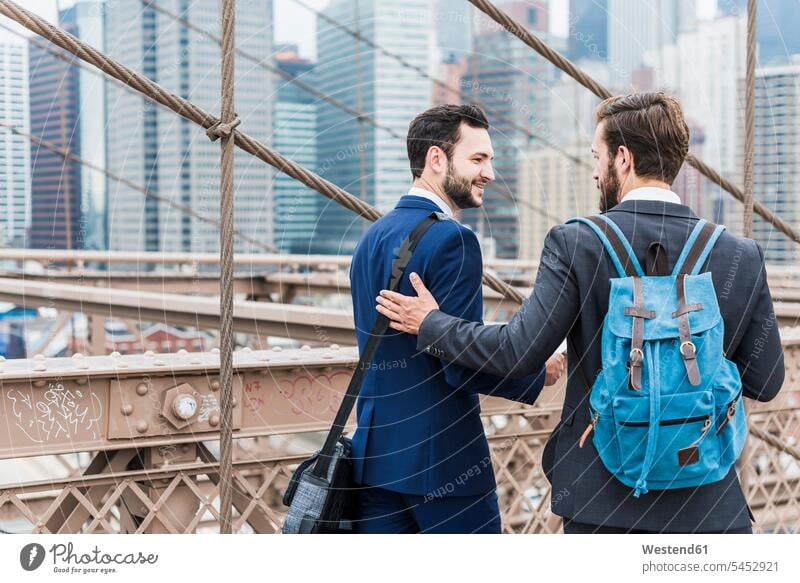 USA, New York City, two businessmen on Brooklyn Bridge talking speaking bridge bridges Businessman Business man Businessmen Business men New York State