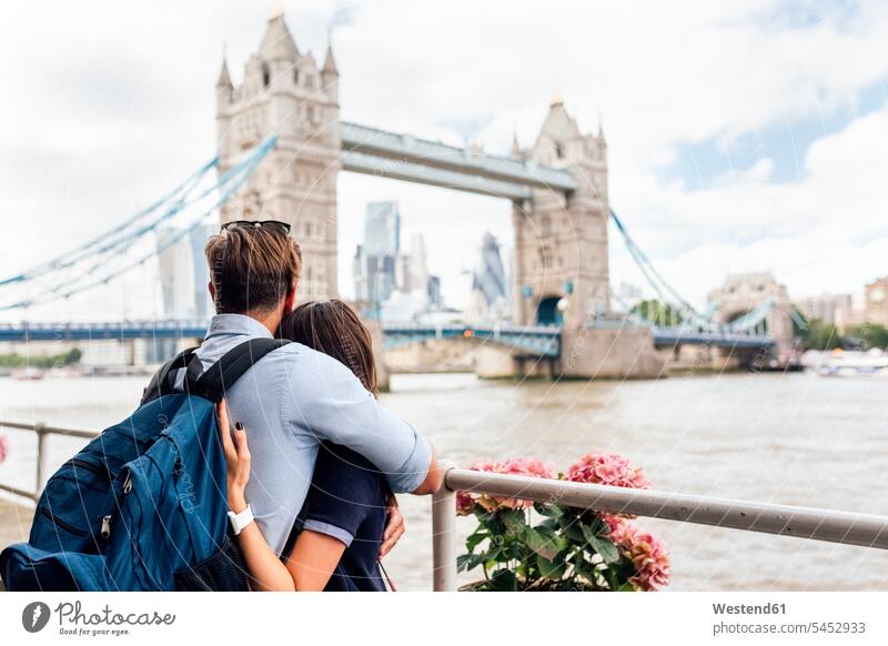 UK, London, couple in love looking at the Tower Bridge twosomes partnership couples embracing embrace Embracement hug hugging England United Kingdom