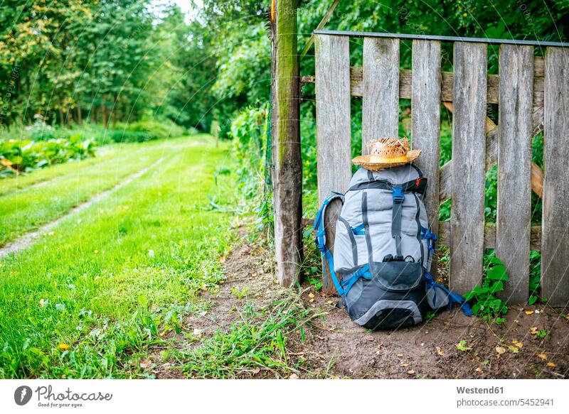 France, Strasbourg, travel backpack and straw hat in front of wooden fence on the way alternative lifestyle day daylight shot daylight shots day shots daytime