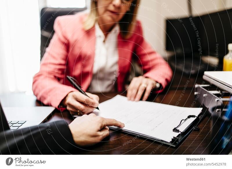 Two businesswomen working on document in office At Work writing write offices office room office rooms businesswoman business woman business women workplace
