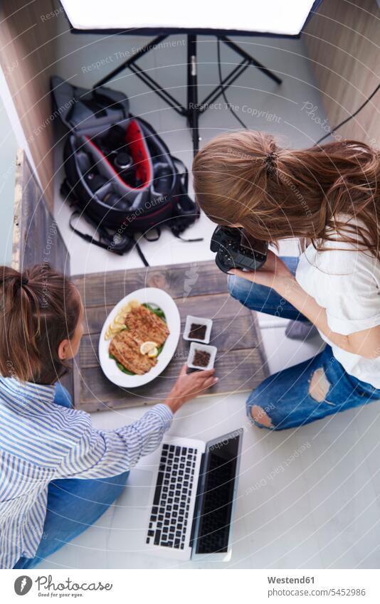 Woman styling prepared dish during photo session cameras photograph human human being human beings humans person persons adult grown-up grown-ups grownup