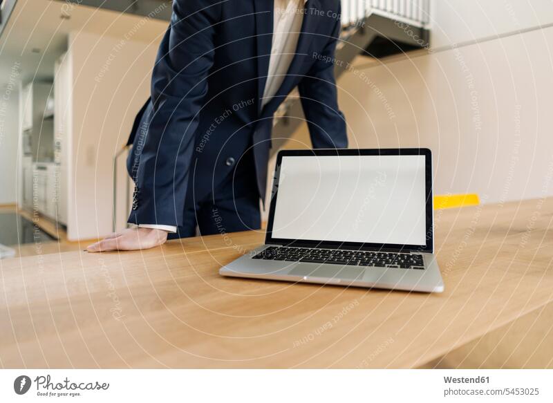 Businessman leaning on table with laptop office offices office room office rooms Laptop Computers laptops notebook Business man Businessmen Business men