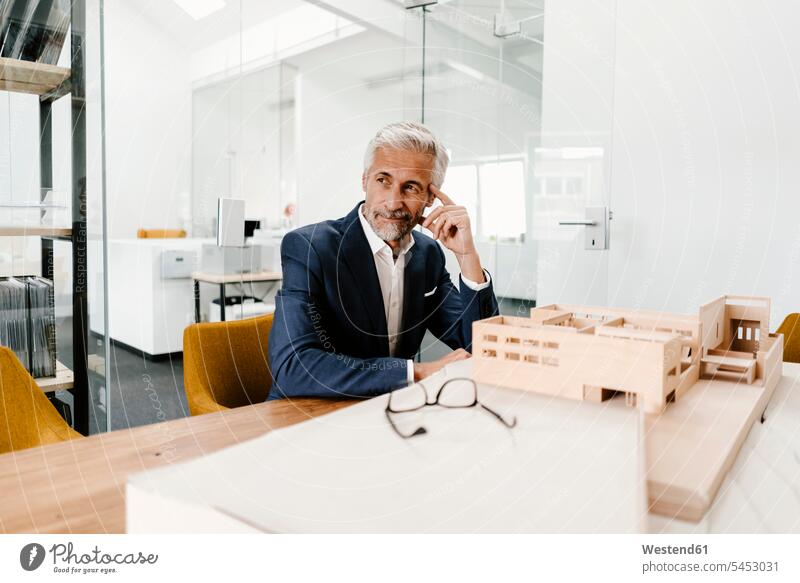 Mature businessman with architectural model in office smiling smile models offices office room office rooms architects Businessman Business man Businessmen