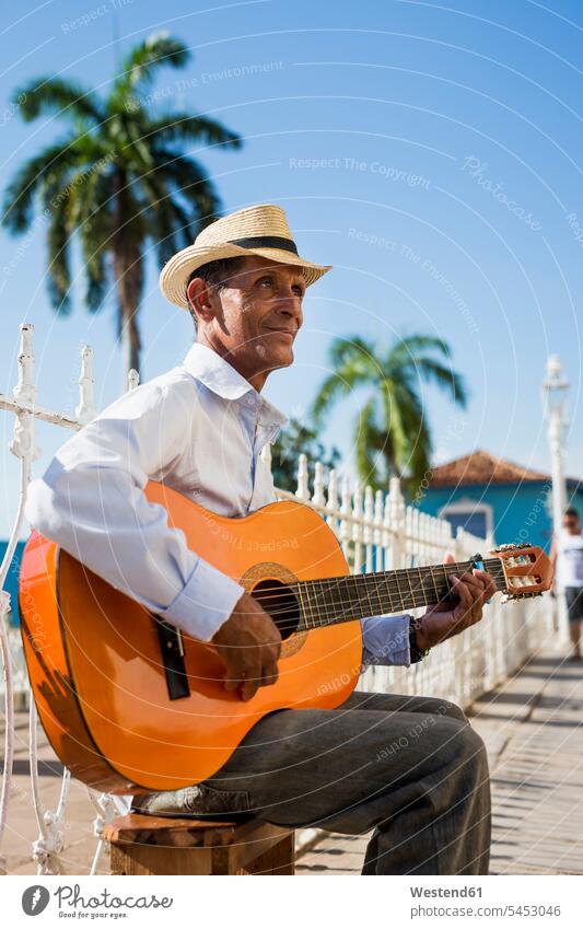 Cuba, Trinidad, man playing guitar on the street street musician street musicians guitars stringed instrument stringed instruments musical instrument