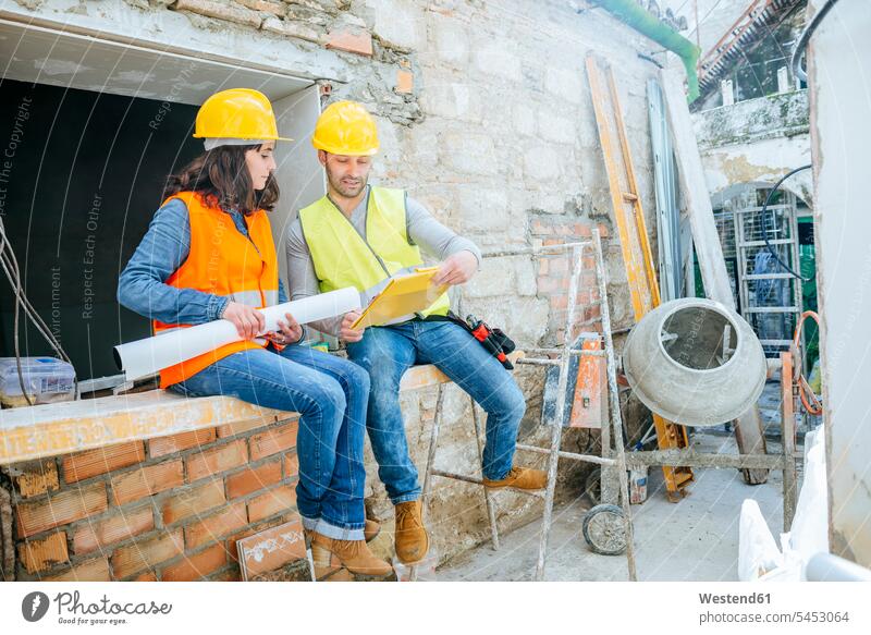 Male and female construction worker talking construction site speaking builders Building Site sites Building Sites construction sites colleagues craftsman trade