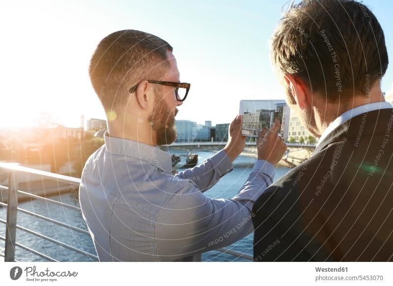 Two businessmen taking a picture with tablet on a bridge in the city talking speaking digitizer Tablet Computer Tablet PC Tablet Computers iPad Digital Tablet