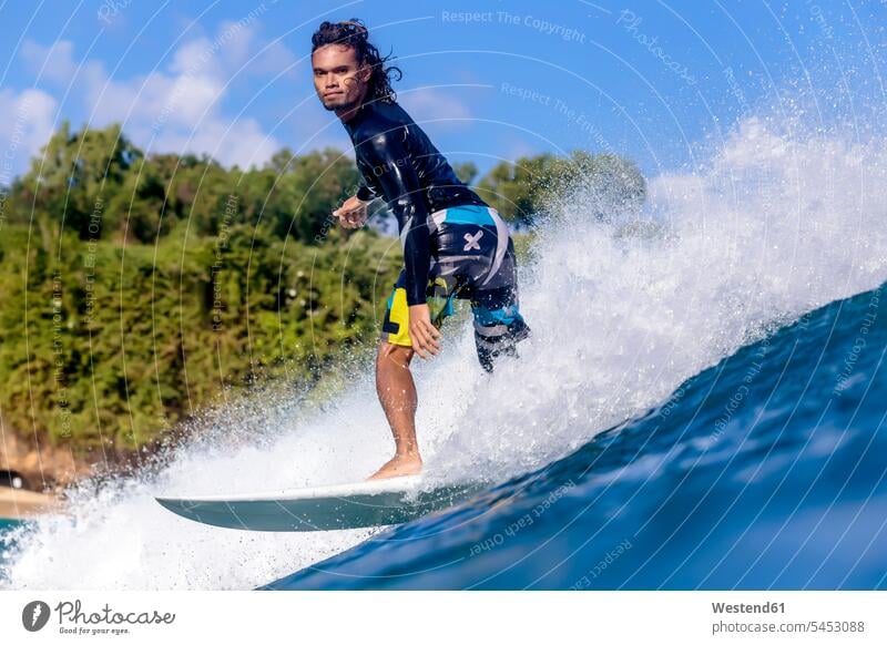 Indonesia, Bali, man surfing wave waves Sea ocean surfer surfers surf ride surf riding Surfboarding water water sports Water Sport aquatics balance balanced