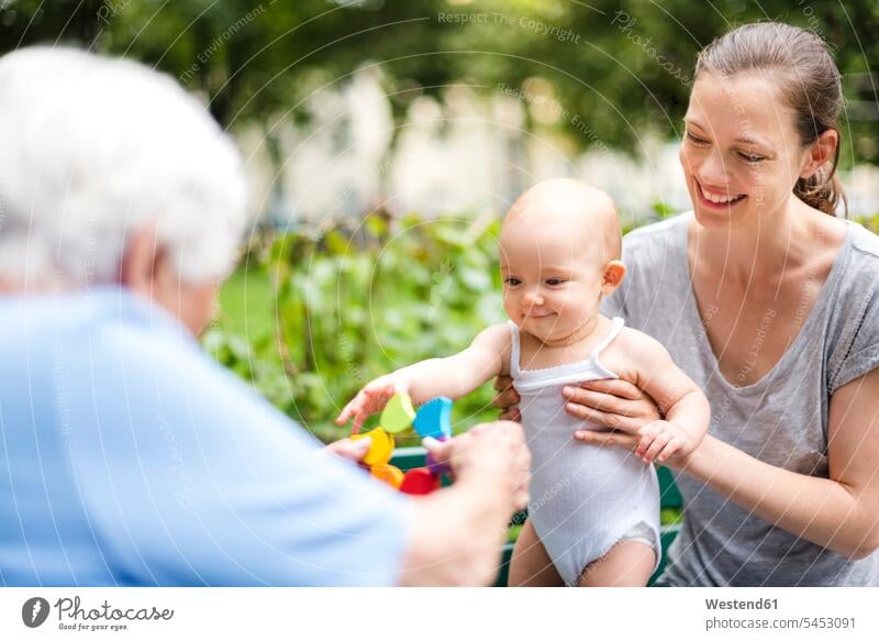 Portrait of smiling baby girl with grandmother and mother in a park mommy mothers ma mummy mama grandmas grandmothers granny grannies parks baby girls female